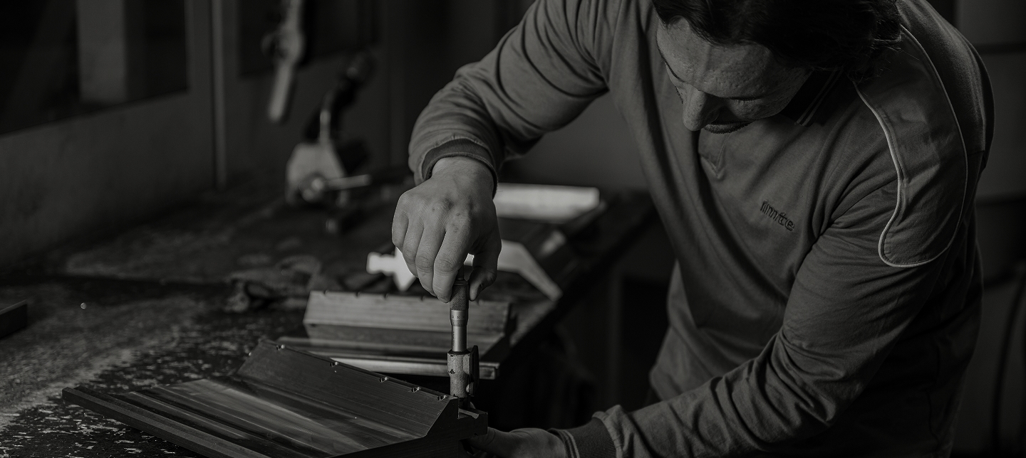 IMTE technician inspecting a press brake tool with precision instruments in a workshop, emphasizing craftsmanship and engineering quality.