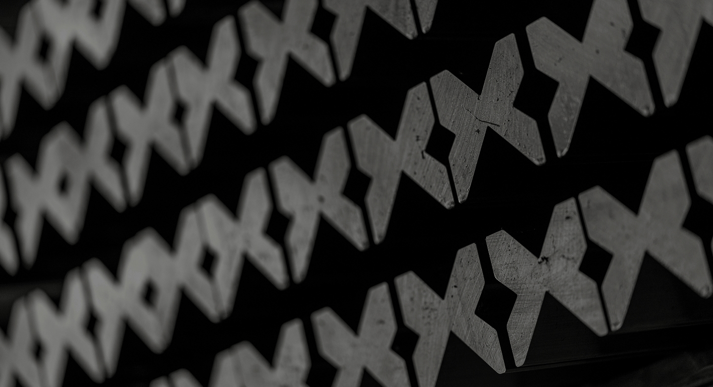 Close-up of precision-machined press brake tooling components arranged in rows, emphasizing craftsmanship and manufacturing quality.